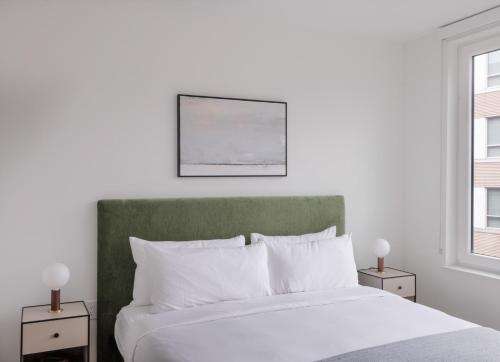 a bedroom with a white bed with a green headboard at ROOST Kelly Drive in Philadelphia