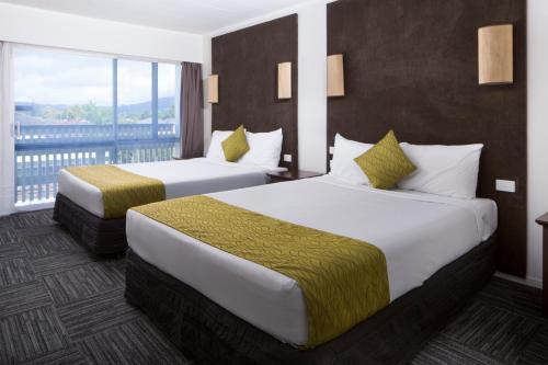 Duas camas num quarto de hotel com varanda em Marsden Stay Rotorua em Rotorua