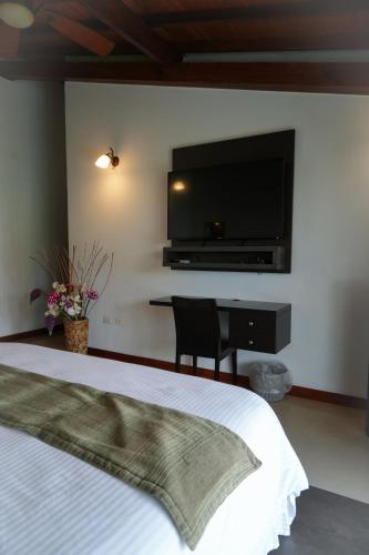a bedroom with a bed and a flat screen tv at Serenity Suites Casa Boutique in Bucaramanga