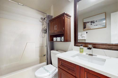 ein Badezimmer mit einem Waschbecken, einem WC und einem Spiegel in der Unterkunft #1 in North Port in North Port
