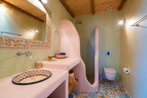 a bathroom with a sink and a large letter k on the wall at Akron Terra Houses in Akrotiri