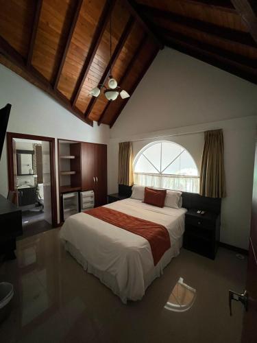 a bedroom with a large bed with a large window at Serenity Suites Casa Boutique in Bucaramanga