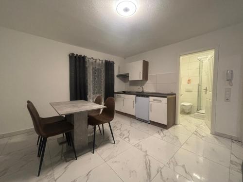 a kitchen with a table and chairs in a room at Safran Apartments Gunzburg in Günzburg