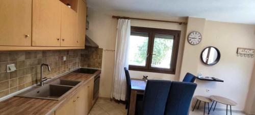 uma cozinha com um lavatório, uma mesa e uma janela em Country House on Mount Olympus em Kariá