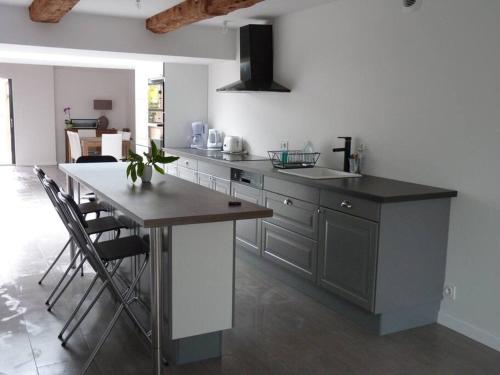 une cuisine avec un comptoir et une table avec des chaises dans l'établissement Le 107 grande maison accès direct et vue sur mer, à Cherrueix