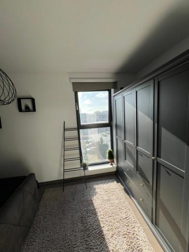 a living room with a window and a couch at Penthouse with awesome terrace and free parking in Kortrijk