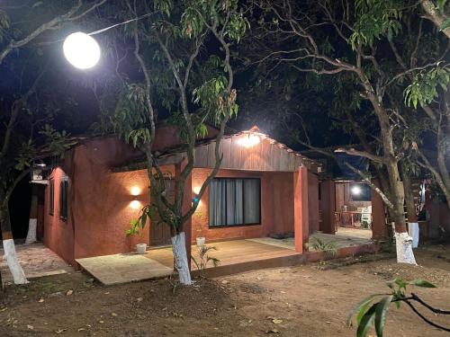 a cabin in the woods at night at The Mango Woods Cottage with Bathtub in Alibag with Swimming Pool in Alibag
