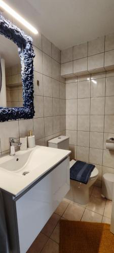 a bathroom with a sink and a toilet and a mirror at Melodia di Mare in Skala Kallirakhis