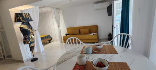 a living room with a table and a couch at Melodia di Mare in Skala Kallirakhis