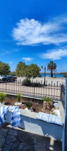 a bench in front of a beach with a fence at Melodia di Mare in Skala Kallirakhis