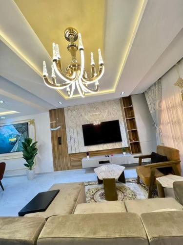 - un salon avec un canapé et un lustre dans l'établissement A & E apartment, à Lekki