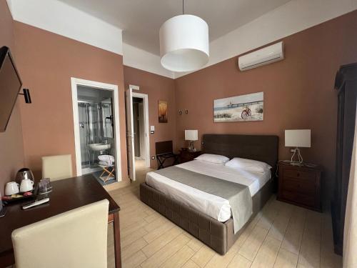 1 dormitorio con 1 cama grande, escritorio y lavamanos en Relais Ranieri en Nápoles