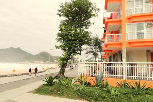 een boom voor een gebouw naast een strand bij KS Beach Hotel in Rio de Janeiro