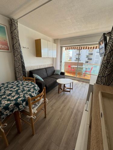 un salon avec un canapé et une table dans l'établissement Studio cabine refait à neuf , vue bassin Arcachon, à Arcachon