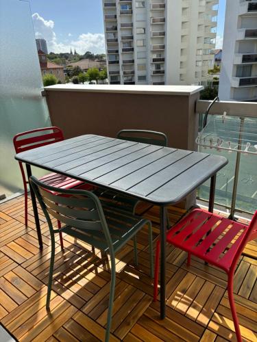 d'une table et de chaises en bois sur un balcon avec une table et des chaises. dans l'établissement Studio cabine refait à neuf , vue bassin Arcachon, à Arcachon
