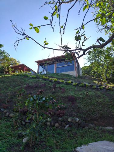 a house on top of a grassy hill at Aldayah Tiny Village in Bajo Boquete