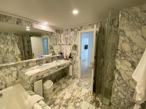 uma casa de banho com 2 lavatórios e um chuveiro em Anfi Beach Club 29 Jul a 04 Ago em Las Palmas de Gran Canaria