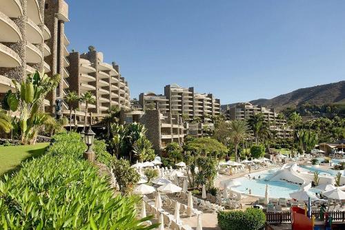 a view of a resort with a pool and buildings at Anfi Beach Club 29 Jul a 04 Ago in Las Palmas de Gran Canaria