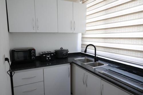 a small kitchen with a sink and a microwave at SERENITY Home in Spintex