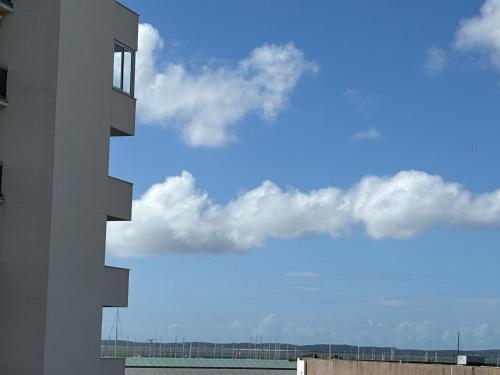 un bâtiment avec un ciel bleu et des nuages dans l'établissement Studio cabine refait à neuf , vue bassin Arcachon, à Arcachon