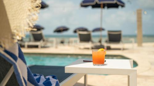a drink sitting on a table next to a pool at Scrub Island Resort, Spa & Marina in The Mill