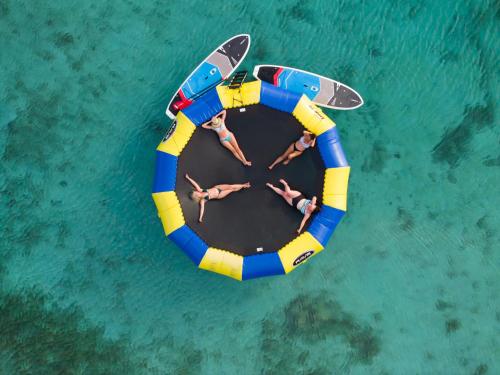 three people in an inflatable circle on the water at Scrub Island Resort, Spa & Marina in The Mill