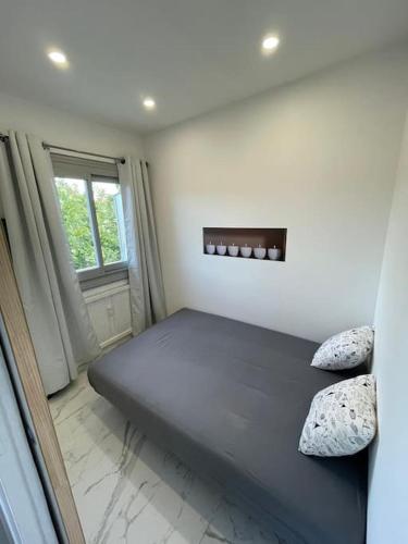 un lit dans une chambre avec une fenêtre dans l'établissement Joli T2 cannes / croisette, à Cannes