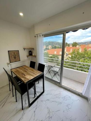 une salle à manger avec une table et une grande fenêtre dans l'établissement Joli T2 cannes / croisette, à Cannes