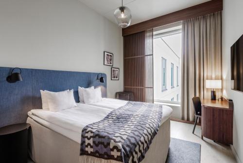 a hotel room with a bed and a window at Clarion Collection Hotel Tapetfabriken in Stockholm