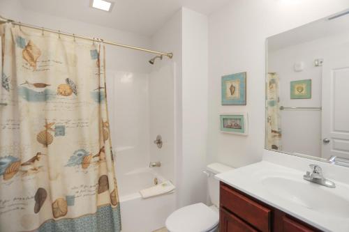 a bathroom with a shower curtain and a toilet at Waterside Village Condo 302 in Mexico Beach