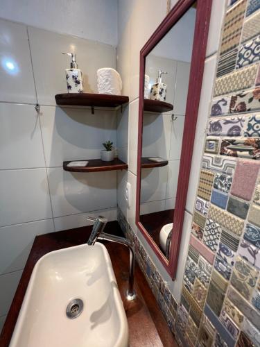 a bathroom with a sink and a mirror at Hospedagem Casa Maracujá in Trindade