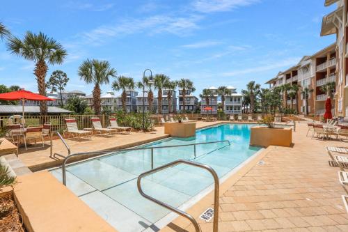 a pool at a resort with chairs and tables at Waterside Village Condo 302 by Pristine Properties Vacation Rentals in Mexico Beach