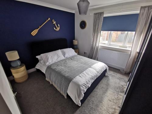 a bedroom with a bed with a guitar on the wall at Nautical nook, East Yorkshire two bed flat, free parking and WiFi in Hull