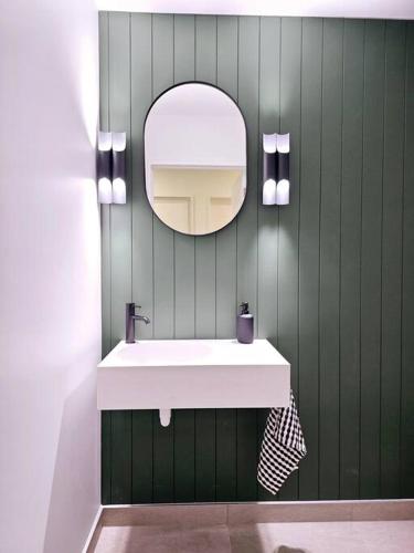 a bathroom with a white sink and a mirror at Spacious Family Home in Kirwee