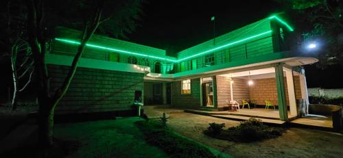 a house with green lights on it at night at Lala Inn Kikopey in Gilgil