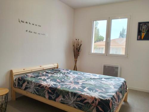 une chambre avec un lit dans une pièce avec une fenêtre dans l'établissement Maison l'Angelina, à Pinet