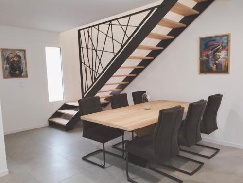 une salle à manger avec une table en bois et des chaises noires dans l'établissement Maison l'Angelina, à Pinet