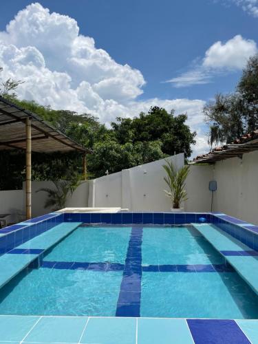 uma piscina com azulejos azuis ao lado de uma casa em Ancestral Casa de Campo em Roldanillo