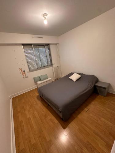 une chambre avec un grand lit et un parquet dans l'établissement Cosy flat all confort Puteaux, à Puteaux