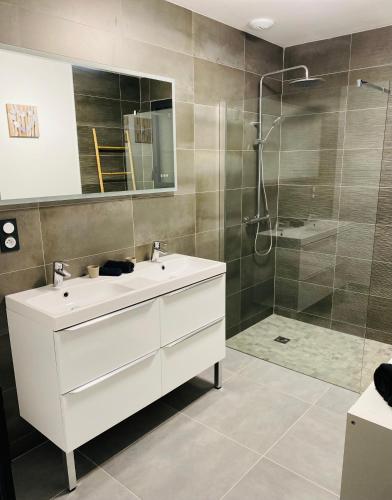une salle de bain avec un lavabo blanc et une douche dans l'établissement Appartement en Camargue, à Aigues-Mortes