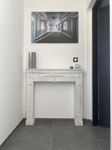 une console dans une pièce avec un tableau au mur dans l'établissement Appartement en Camargue, à Aigues-Mortes