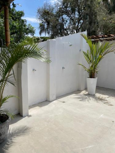 a white fence with two potted plants on a patio at Ancestral Casa de Campo in Roldanillo