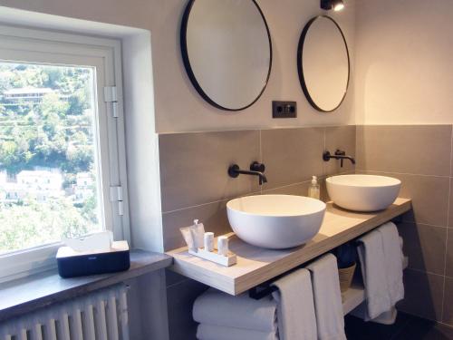a bathroom with two sinks and mirrors on the wall at Villanova Apartments - Nature & Wellness in Levanto