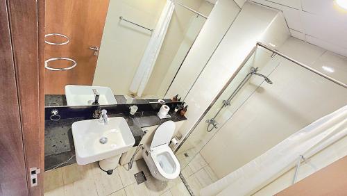 a bathroom with a sink and a toilet and a mirror at Marasi Moods 2BD on Burj Khalifa and Canal views in Dubai