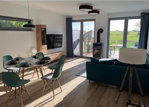 a living room with a blue couch and a table and chairs at The Fehmarn Lodges - EMOTION - in Fehmarn