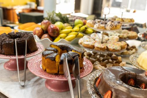 a table filled with different types of cakes and pastries at Hotel Golden Star in Curitiba