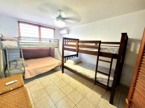 2 Etagenbetten in einem Zimmer mit Ventilator in der Unterkunft Ocean front Vacation home near el Rain forest in Luquillo