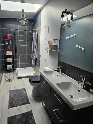 une salle de bain avec un lavabo, des toilettes et une douche dans l'établissement FORREST GUEST HOUSE ; LA MAISON DE FORREST, à Sainte-Marie-du-Mont