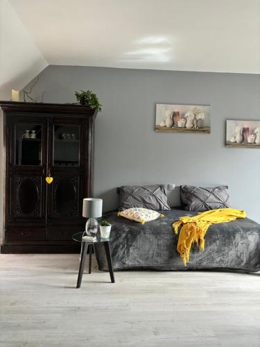 a bedroom with a bed with a yellow blanket on it at Gite le Patis in Pré-en-Pail