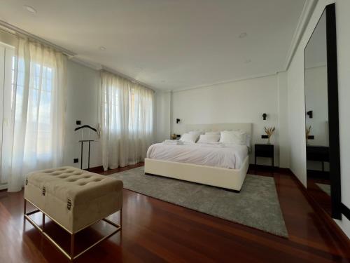 - une chambre avec un lit blanc et une grande fenêtre dans l'établissement Villa Los Olivos, à Bárcena de Cicero